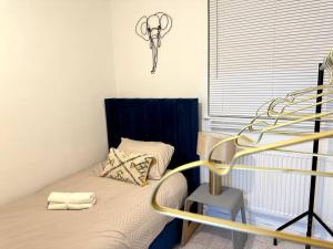 een kleine slaapkamer met een bed met een zwart hoofdeinde bij Luxury 3 Bed Home In London in Londen
