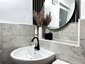 La salle de bains est pourvue d'un lavabo, d'un miroir et de toilettes. dans l'établissement Luxury 3 Bed Home In London, à Londres