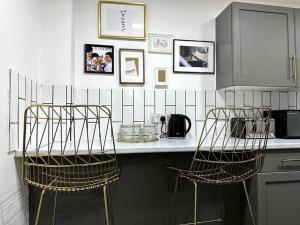 a kitchen with a counter with two metal chairs at Luxury 3 Bed Home In London in London