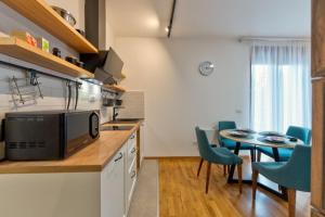a kitchen with a table and chairs and a microwave at Apartman Lukic Luxury&Spa in Zlatibor