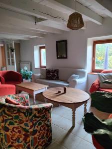uma sala de estar com sofás e mesas em Gîte Au gré du vent - 12 personnes - Calme, nature et confort em La Goutelle