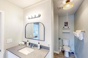 a bathroom with a sink and a mirror and a toilet at Beach Life in Panama City Beach +37 photos