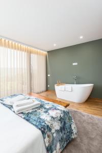 een badkamer met een bed en een bad bij Casas De Bouro 1 in Terras de Bouro