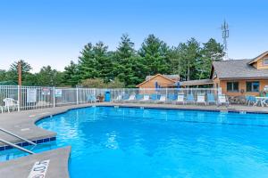 a large swimming pool with chairs and a house at Condo On the Green in Arkdale