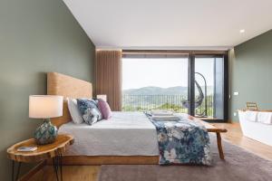 ein Schlafzimmer mit einem Bett und einem großen Fenster in der Unterkunft Casas De Bouro 1 in Terras de Bouro