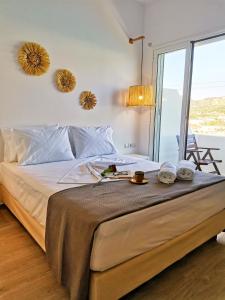 a bedroom with a large bed with towels on it at Galazio Rooms & Suites in Batsi