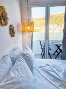 a bedroom with a bed with a view of the ocean at Galazio Rooms & Suites in Batsi