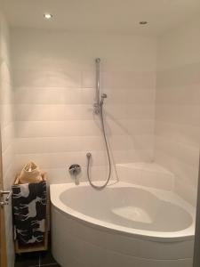 a white bath tub with a shower in a bathroom at Steinadler Seekareck FL - Skiing Holiday in Obertauern in Obertauern
