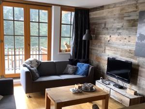 a living room with a couch and a television at Steinadler Seekareck FL - Skiing Holiday in Obertauern in Obertauern