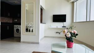 a living room with a vase of flowers on a glass table at Lakeshore Towers, Cluster Y , JLT, 1BHK in Dubai