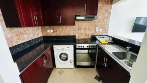 a small kitchen with a washing machine and a sink at Lakeshore Towers, Cluster Y , JLT, 1BHK in Dubai