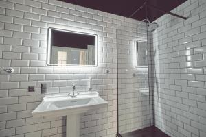uma casa de banho branca com um lavatório e um espelho em Domus Balthasar Boutique Hotel em Praga