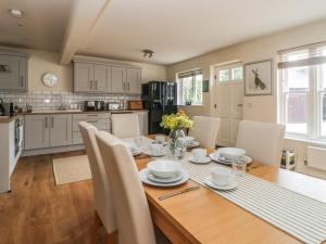 cocina y comedor con mesa de madera y sillas en Little Aluph, en Ashford