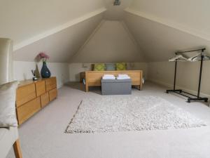a attic room with a bed and a couch at Little Aluph in Ashford