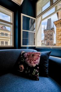 a pillow sitting on a couch in front of a window at Domus Balthasar Boutique Hotel in Prague