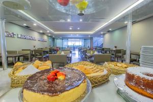 a table with cakes and desserts on it in a restaurant at Hotel Victoria Villa Curitiba by Nacional Inn in Curitiba +76 photos