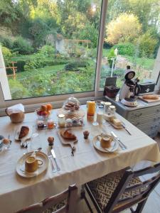 una mesa con desayuno y una gran ventana en Lapis Domus, en Francueil