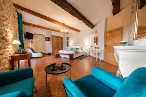 - un salon avec des canapés bleus et une table dans l'établissement L'Instant Sévigné, à Grignan