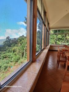 a room with windows and a table and chairs at Camping Magamba Forest in Lushoto