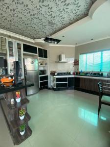 a large kitchen with a stainless steel refrigerator and counters at Mansão Digital in Brasilia