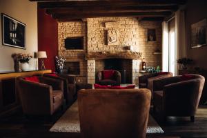 uma sala de estar com cadeiras e uma lareira de pedra em Hôtel & restaurant Le Meysset em Sarlat-la-Canéda