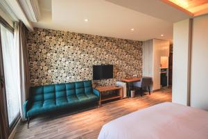 Chill hill cottage في Taiping: غرفة في الفندق مع أريكة خضراء ومكتب