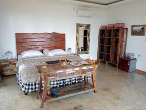 a bedroom with a bed and a wooden table at Private Villa - Ocean, hills, valley view in Temukus