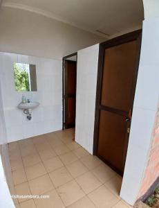 an empty bathroom with a sink and a door at Camping Magamba Forest in Lushoto