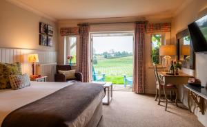 a hotel room with a bed and a large window at Three Choirs Vineyards in Newent