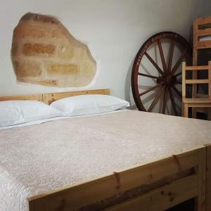 ein Bett mit einem holzdokumentierten Rad in einem Schlafzimmer in der Unterkunft Japp'ca Japp'ca in Castellaneta