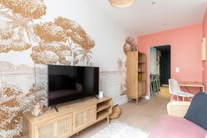 a living room with a flat screen tv on a wooden entertainment center at Appartement élégant proche Tramway & Centre-Ville in Nantes +3 photos