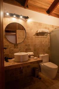 een badkamer met een wastafel, een toilet en een spiegel bij Viscas Lodge in Carhuaz