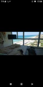Blick auf ein Schlafzimmer mit einem Bett und einem Fenster in der Unterkunft שרון על המים in Herzliya B