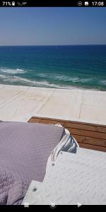 ein Bett am Strand mit dem Ozean im Hintergrund in der Unterkunft שרון על המים in Herzliya B