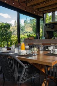 a wooden table with chairs and a large window at Viscas Lodge in Carhuaz