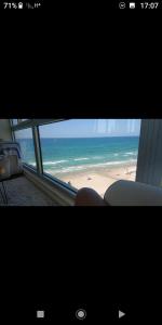 a view of a beach from a window at שרון על המים in Herzliya B