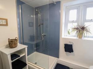 een badkamer met een douche met een glazen deur bij Kestrel Cottage in Keswick +31 foto's