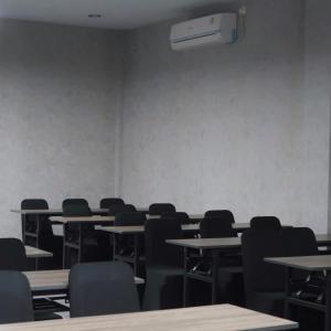 an empty room with tables and chairs and a projector at Fhandika Boutique Inc. in Geutieue