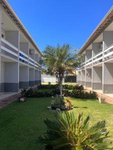 um pátio de um edifício com palmeiras e plantas em Temporada em Cabo Frio em Cabo Frio