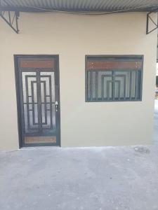 a pair of doors on a white building at Alojamiento la esmeralda in Puerto Triunfo
