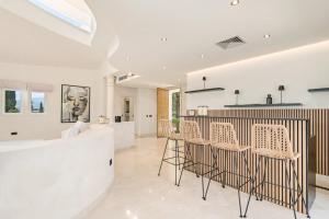 a kitchen and dining room with white walls and a bar at All About La Redonda Villa in Estepona