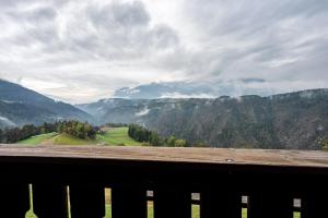 uma vista para um vale montanhoso a partir de um banco de madeira em Ferienwohnung Gatscherhof em Luson