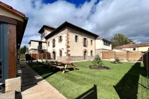 a large house with a picnic table in the yard at Las Casonas de Don Pedro in Reinosa