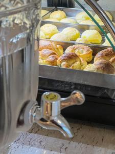 a machine with a bunch of croissants and pastries at Pousada Cabanas Rota do Sol in Gramado