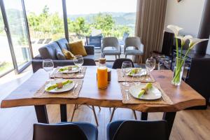 - une table en bois avec des assiettes de nourriture et des verres à vin dans l'établissement Casas de Bouro 2, à Terras de Bouro