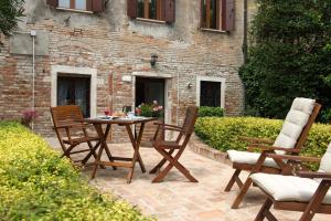 een terras met een tafel en stoelen voor een gebouw bij San Giacomo in Venetië
