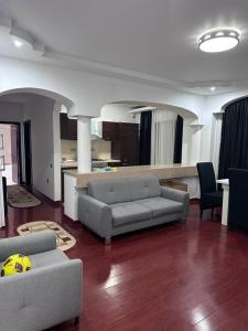 a living room with two couches and a kitchen at Apartament Complex in Bucharest