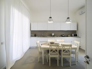 a white kitchen with a table and chairs at Villa Rita in Marsala
