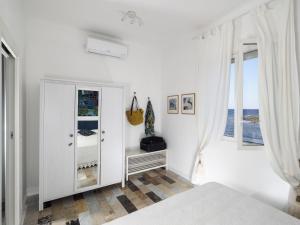 una camera bianca con letto e specchio di Rifugio a Mare a Calabernardo