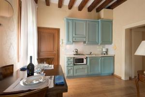una cocina con armarios azules y una mesa con un plato. en Rialto, en Venecia